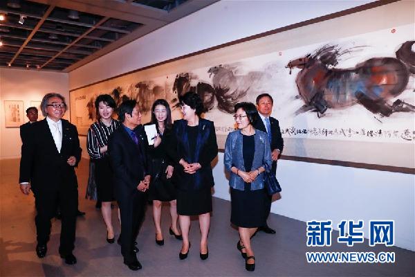 在韩国首尔，中国艺术家韩美林（左前）陪同来宾参观展览